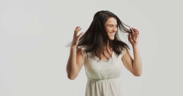 Joyful Woman Playing with Hair in White Dress on Light Background - Download Free Stock Images Pikwizard.com