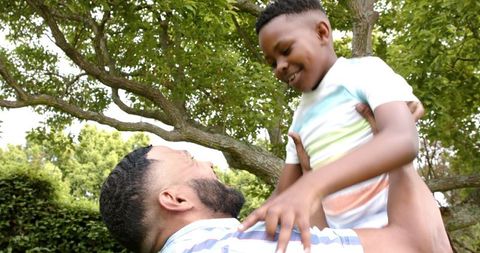 Father Playfully Lifting Son Joyful Outdoor Moment - Download Free Stock Images Pikwizard.com