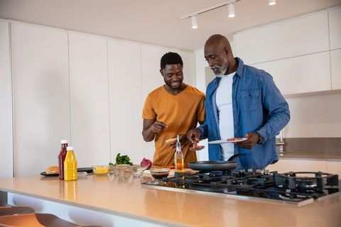 Father and son cooking breakfast together at home