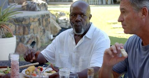 Senior Friends Sharing Meal on Patio with Fresh Stir Fry
