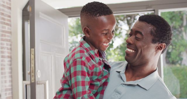 Portrait of happy african american father with son. Spending quality time with family at home together.