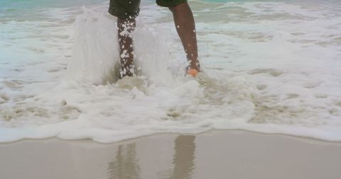 Man Enjoying Sea Waves on Beach with Splashes