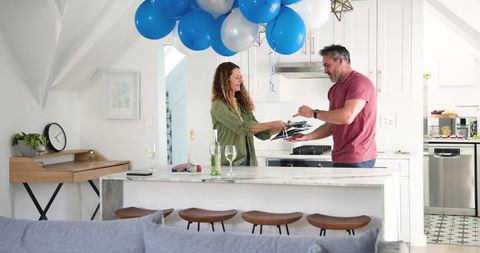Couple cleaning after birthday together in modern kitchen