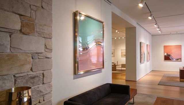 Displaying pastel abstract art in contemporary gallery interior with gold frame above sofa