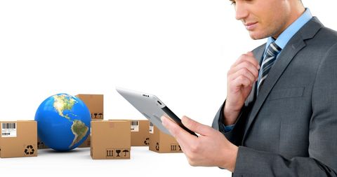 Businessman Using Tablet with Shipping Boxes and Globe