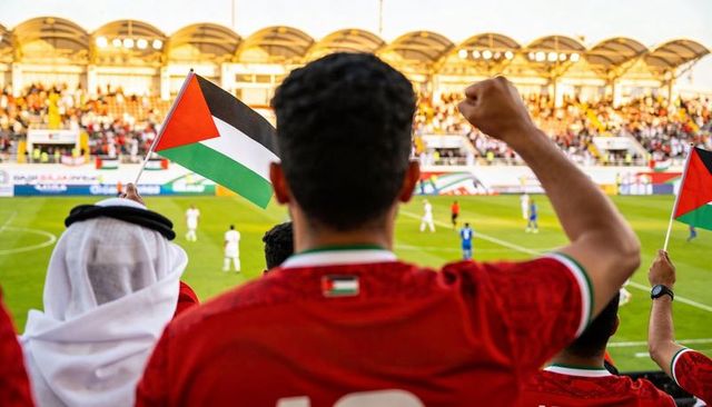 Passionate palestinian fans waving flags and cheering at stadium football match