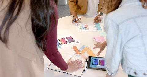 Collaborative Team Reviewing Color Swatches with Tablet