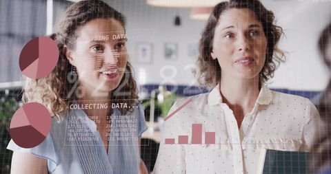 Businesswomen discussing financial analytics in modern office