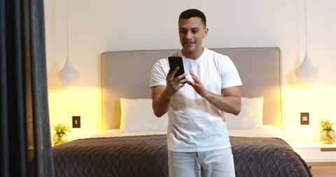 Man Video Chatting on Smartphone in Modern Bedroom Interior