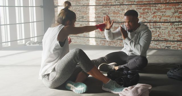 Image of happy fit diverse woman and man boxing at gym. active, fit, sporty and healthy lifestyle, exercising at gym concept.