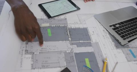 Architects Collaborating on Project with Blueprint and Gadgets