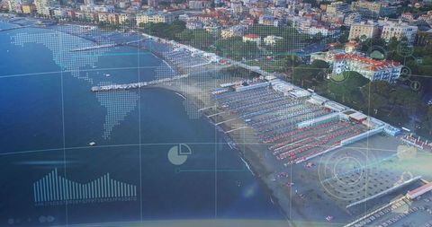 Aerial coastal scene showing beach resort with sunbeds, umbrellas, piers and HUD overlays