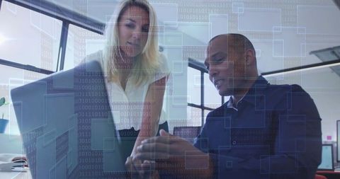 Colleagues analyzing technology data overlay on laptop screen