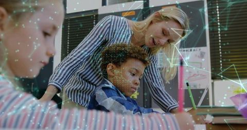 Teacher Assisting Students in Tech-Connected Classroom