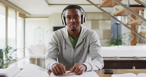 Young adult with headphones studying at home for online learning