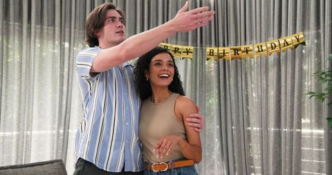Multiracial Couple Preparing Decorations for Birthday Celebration at Home