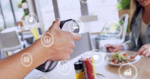 Server presenting contactless card reader with augmented reality icons over cafe table