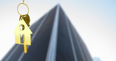 Golden house key in cityscape background for real estate success