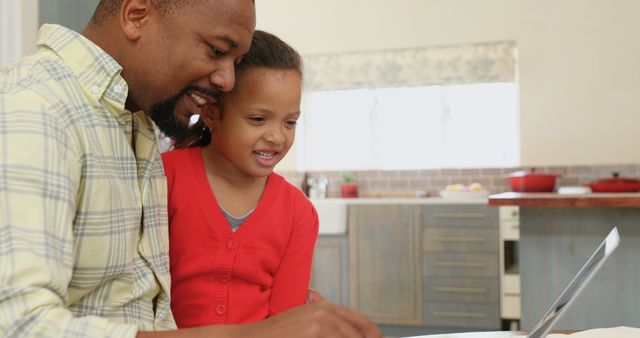 A father and daughter bond over technology in their kitchen, emphasizing family and tech unity. - Download Free Stock Photos Pikwizard.com