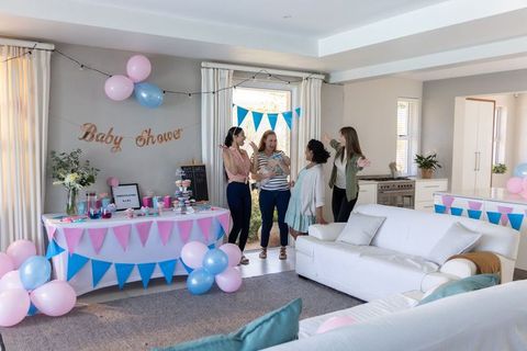 Diverse Friends Chatting at Baby Shower in Decorated Living Room