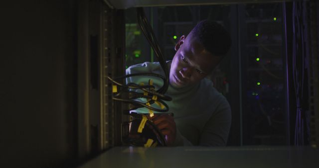 African American Technician Working with Server Racks in Low Light - Download Free Stock Images Pikwizard.com