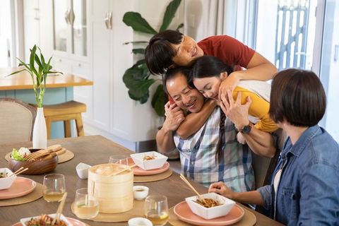Diverse Family Sharing Loving Embrace at Cozy Dining Table