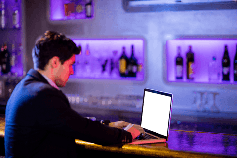 Transparent view businessman using laptop in modern bar lounge