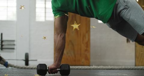 Athlete holding dumbbell in renegade plank training core strength and stability