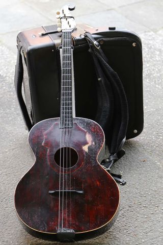 Rustic Vintage Guitar and Travel Suitcase Outdoors
