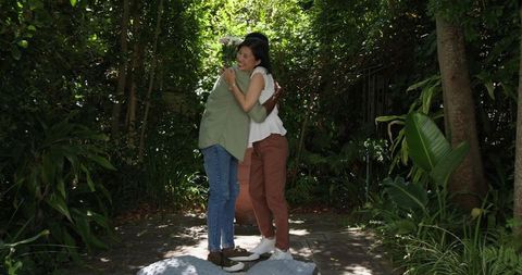 Couple Sharing Flowers in a Lush Garden Embracing Joyfully