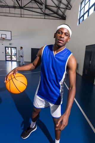 Focused African American Athlete Holding Basketball on Indoor Court