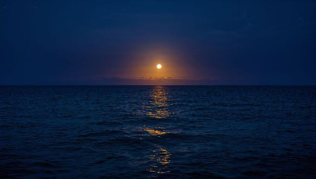 Full Moon Rising Over Calm Ocean With Golden Reflection and Minimalist Night Horizon