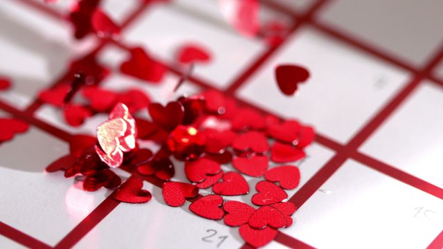 This image captures red heart-shaped confetti scattered across a calendar, symbolizing romantic or special occasions. Perfect for promoting Valentine's Day events, romantic campaigns, or marking celebratory dates. Its festive and affectionate style makes it ideal for greeting cards, social media posts, or editorial purposes related to love and relationships.