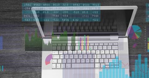 Top-down laptop keyboard showing translucent data charts and analytics dashboard overlays