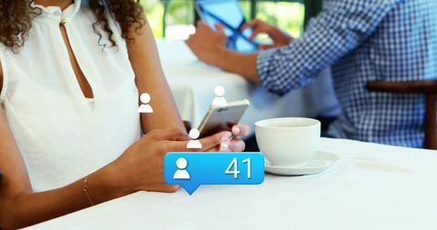 Woman holding smartphone at cafe with floating social notification bubble showing 41 followers