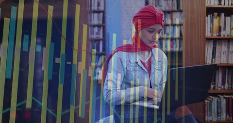 Young Female Student Analyzing Data on Laptop in Library