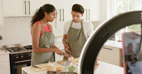 African American Couple Filming Cooking Tutorial in Sunlit Modern Kitchen with Ring Light