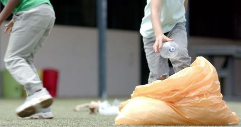 Children Cleaning Up School Playground by Collecting Trash