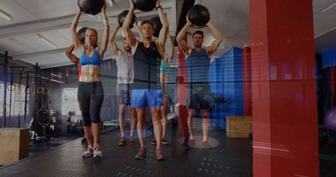 Group fitness class with medicine balls in modern gym