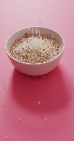 Himalayan pink salt in bowl on vibrant pink surface
