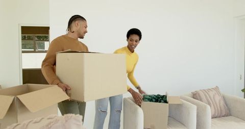 Couple Unpacking Moving Boxes in Bright Living Room