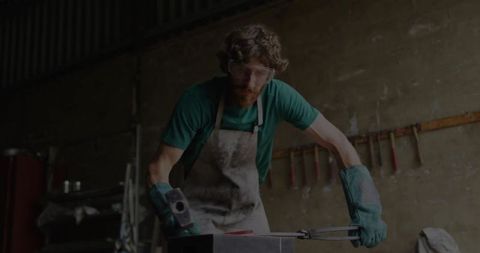Skilled Blacksmith Hammering Red Hot Iron in Industrial Workshop