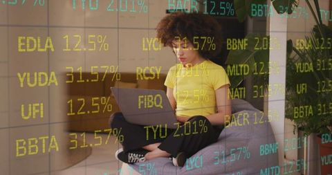 Businesswoman analyzing stock data on laptop with futuristic interface