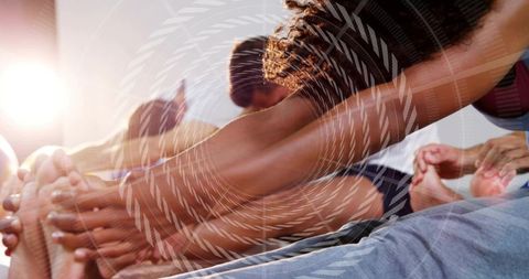 Group stretching and reaching forward in yoga class with sunlight and spiral overlay