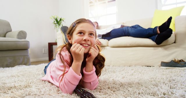 Young Girl Watching TV Lying on Living Room Carpet - Download Free Stock Images Pikwizard.com