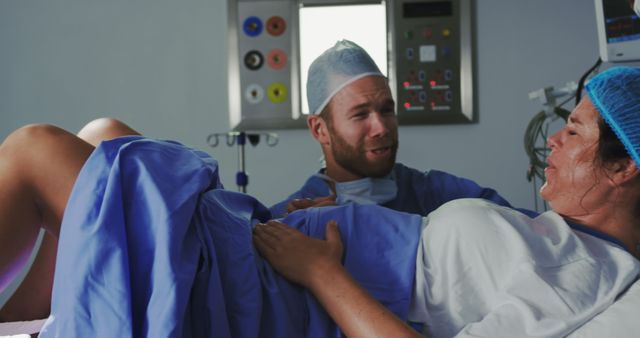 A surgeon comforts a pregnant woman in labor during a hospital operation. - Download Free Stock Photos Pikwizard.com