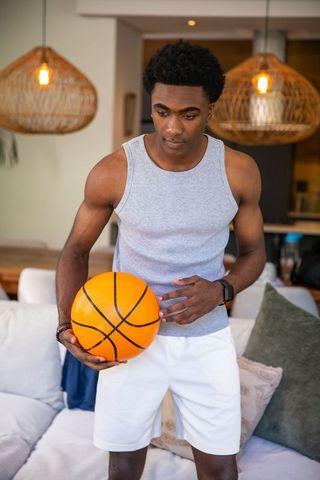Athletic Man Holding Basketball in Stylish Living Room Interior