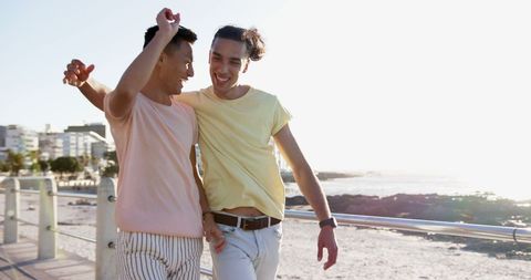 Joyful Gay Couple Strolling by Marina at Sunset