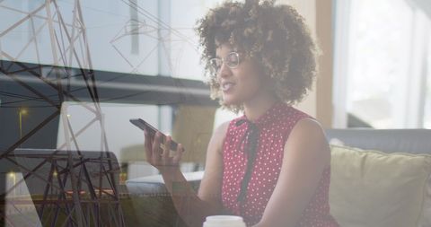 Businesswoman Using Smartphone Overlaid with Cityscape