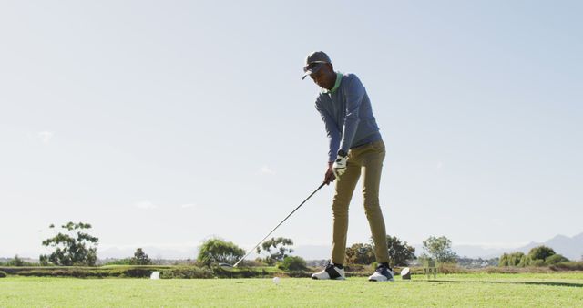Image of african american man playing golf on golf field. sporty, active lifestyle and playing golf concept.